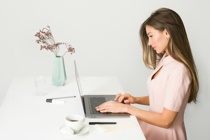 Woman reviewing her pipeline on a laptop in bright daylight