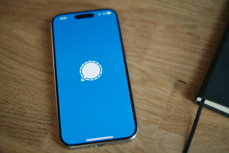 Smartphone resting on a warm wooden table, editorial home crop