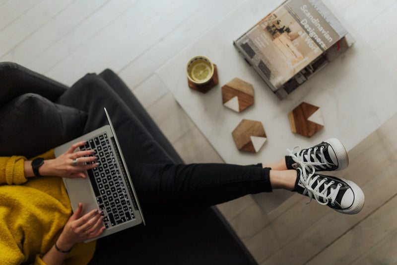 Woman working at her laptop in warm natural light during a focused home work session